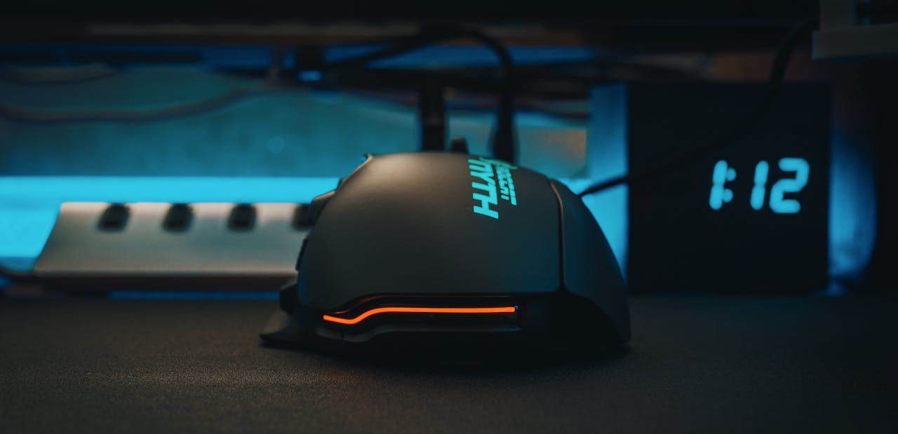 Close-up of a futuristic gaming mouse next to a digital clock, showcasing modern technology.
